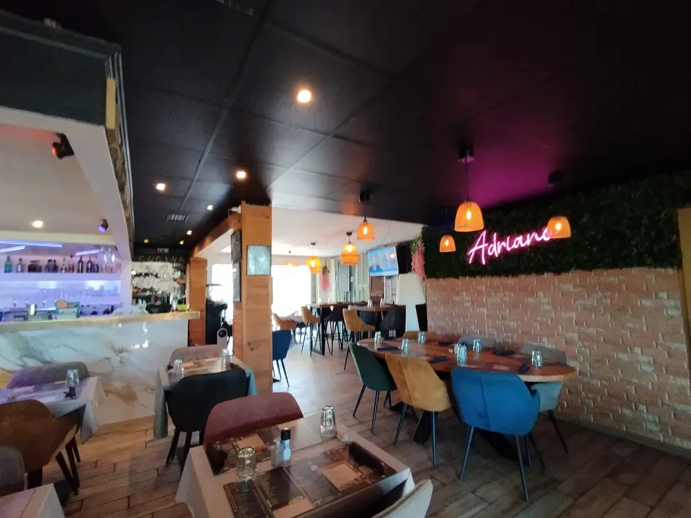 Restaurant area with brick wall, pink neon sign and large group table