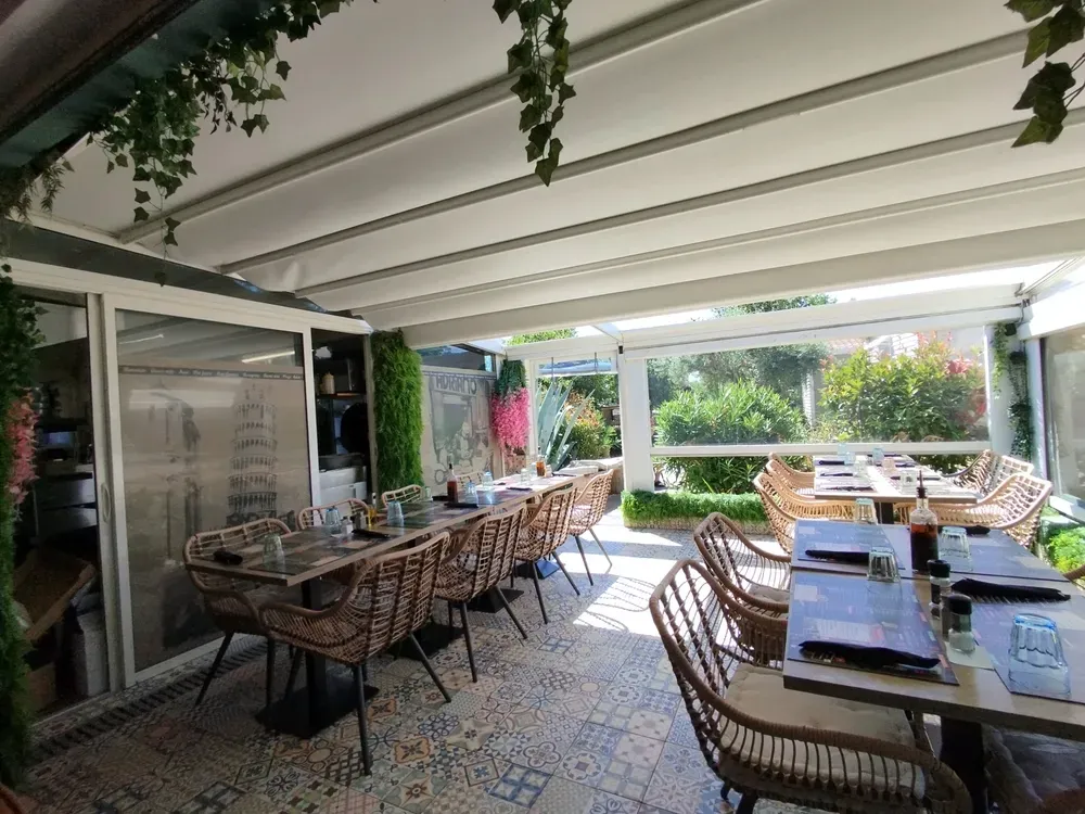 Shaded restaurant terrace with pergolas and wicker furniture